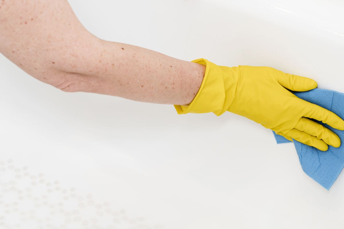 Gloved hand wiping a bright white surface during a professional deep cleaning