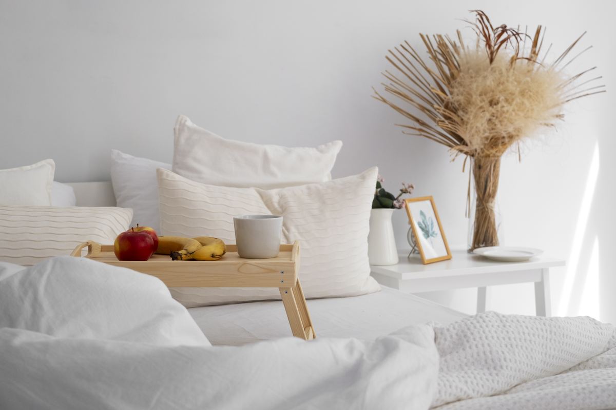 Freshly made bed with clean white linens in a calm, tidy bedroom