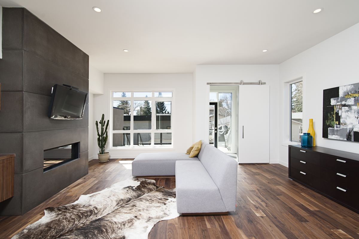 Spotless modern living room with white walls and wood floors after a professional cleaning