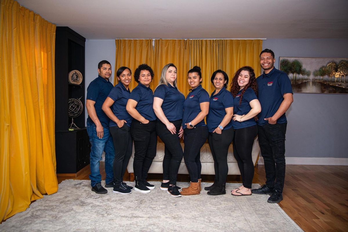 The Maggie's Magic Touch cleaning team standing together in matching navy shirts